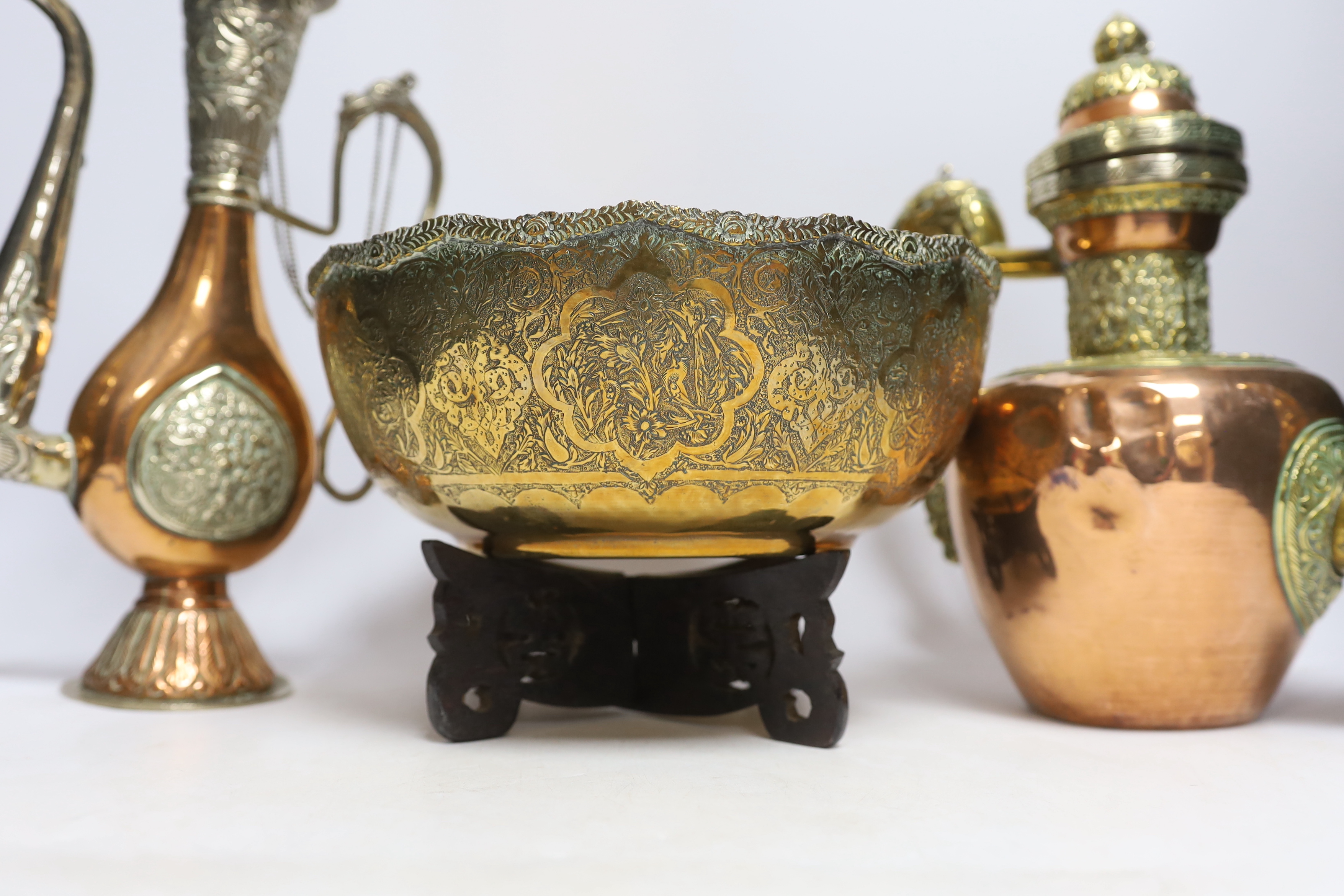 Four Tibetan overlaid copper teapots and an engraved brass bowl, tallest 34cm